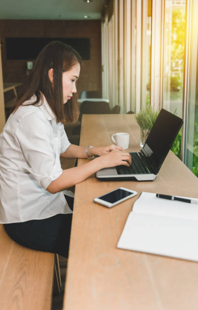 istock Beautiful woman using laptop at cafe 871632114