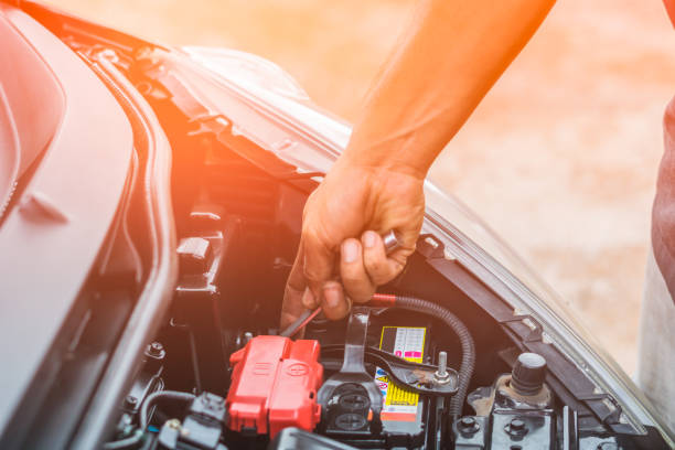 mano della batteria dell'autoca meccanica nell'officina di riparazione auto - battery replacement foto e immagini stock