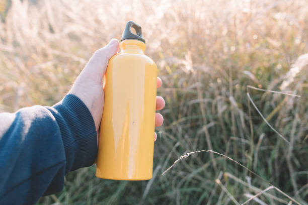 istock Yellow bottle in hand. Travel concept. 871635132
