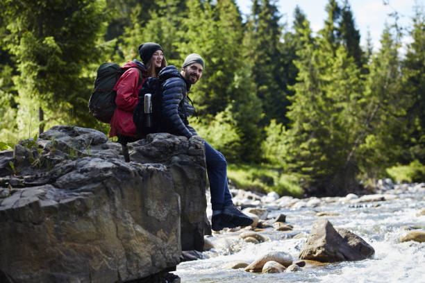 istock Couple resting on a rock above river 871644470