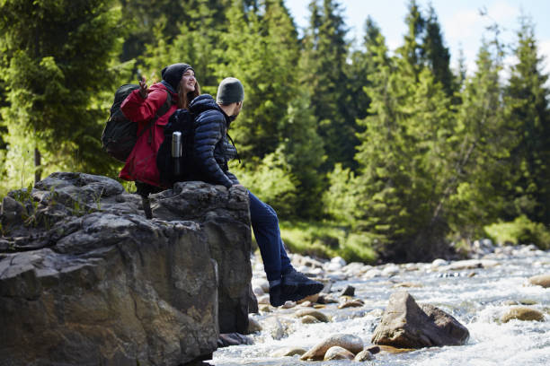 istock Couple resting on a rock above river 871644512