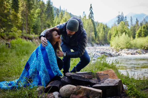 istock Man covering his girlfriend with blanket. Springtime in mountains 871645168