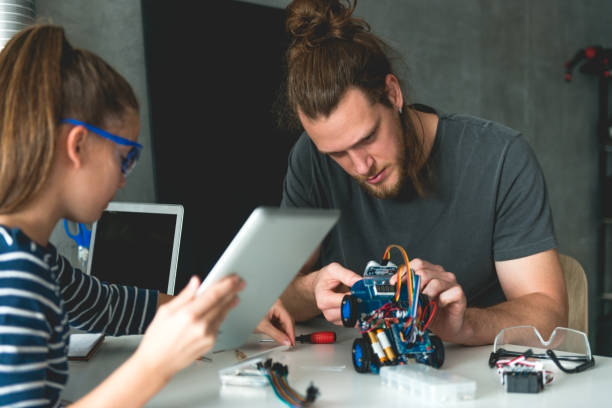 istock Father helping daughter to build mechanical car 871645224