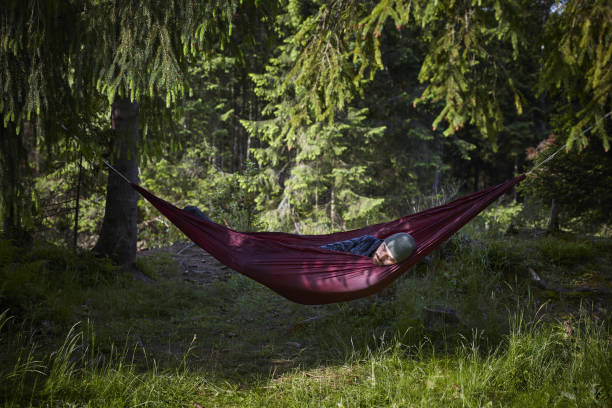 istock Man sleeping in hammock. Outdoor relaxation 871645284