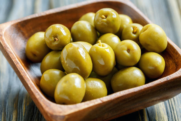 istock Green olives in a bowl close-up. 871668120