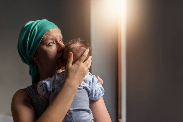donna in velo che tiene in braccio il suo bambino e alza lo guardando in alto - cancer chemotherapy drug baby family foto e immagini stock