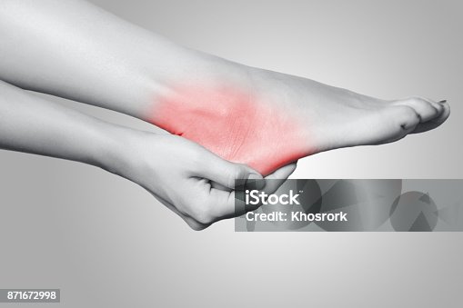 istock Closeup view of a young woman with pain on leg on gray background. 871672998