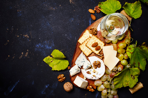 White Dry Wine, Cheese With Mold, Nuts, Grape And Cracker, Dark Background, Top View