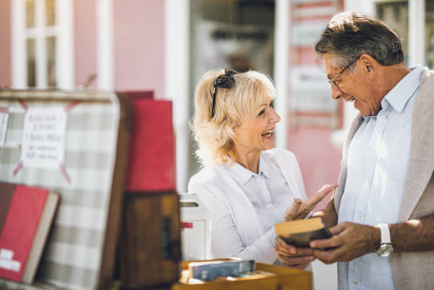 istock Mature Couples Looking at Books on Street 871680174