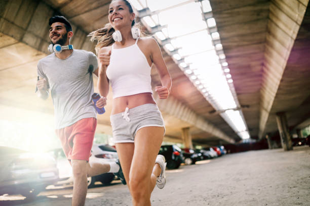 istock Attractive man and beautiful woman jogging together 871691754
