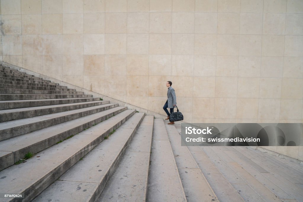 Climbing the steps to success Profile shot of a businessman walking stairs up to work in the city of Paris. Staircase Stock Photo