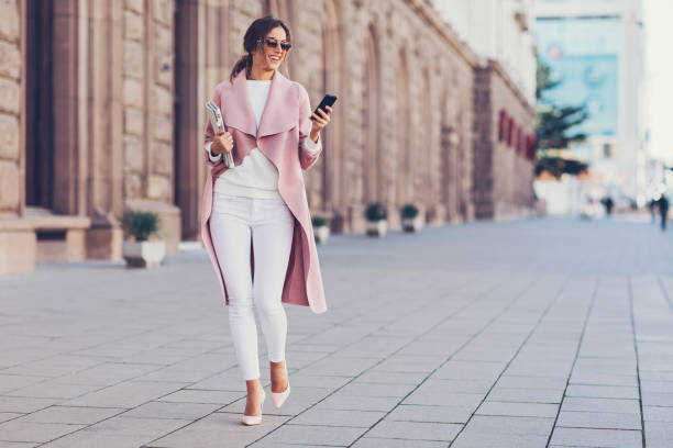 бизнесвумен гуляет по улице - beautiful pink business finance стоковые фото и изображения