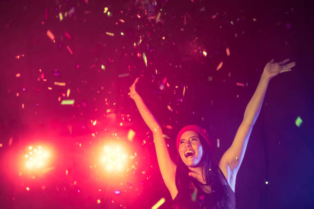 istock Happy woman dancing under confetti at a party 871695714