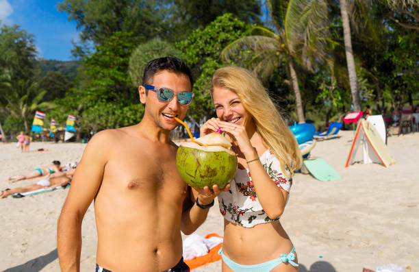 istock Attractive man whit woman drinking coconut 871696970
