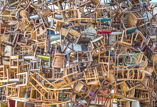hundreds of vintage chairs stacked in a pile