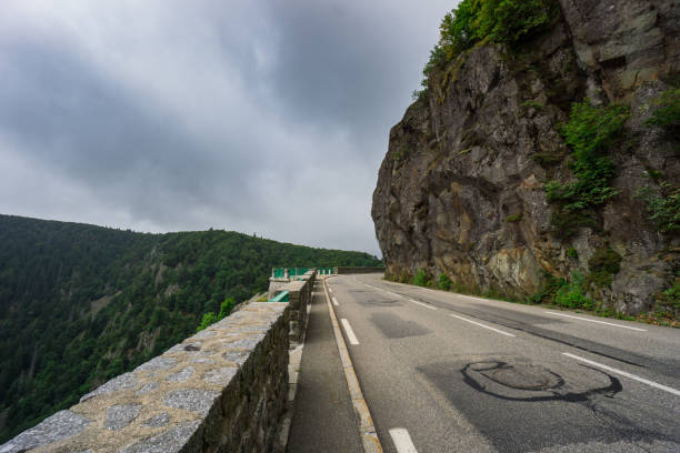 France - Curved street of route de cretes next to massive rocks in mountains of vosges stock photo