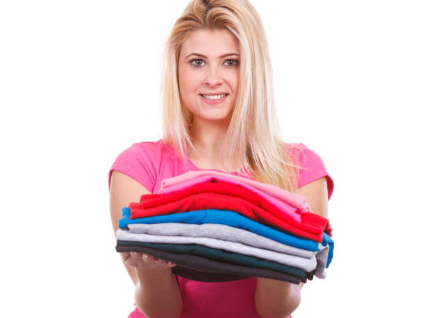 istock Woman holding pile of folded clothes 871708382