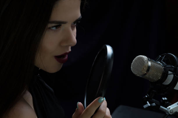 istock Beautiful girl singing In Recording Studio with microphone 871710584