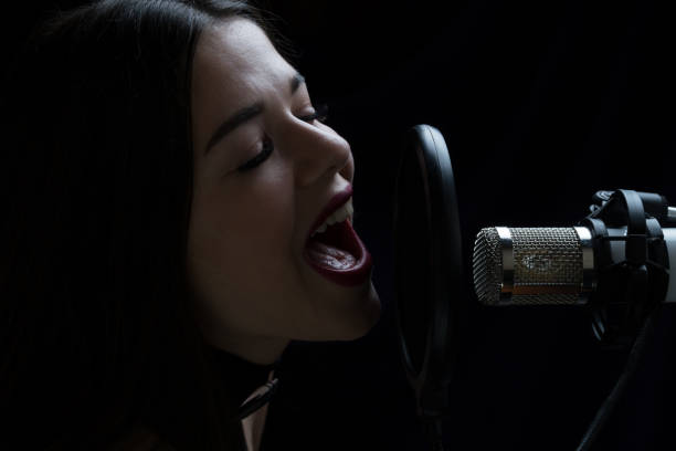 istock Beautiful girl singing In Recording Studio with microphone 871710836