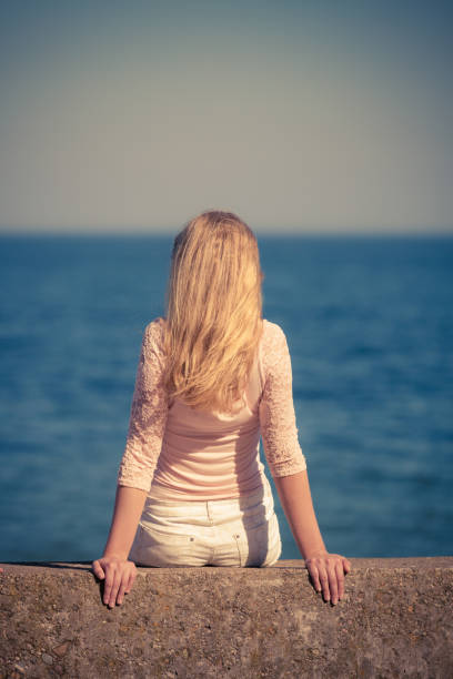 istock Woman looking to sea horizon 871711240