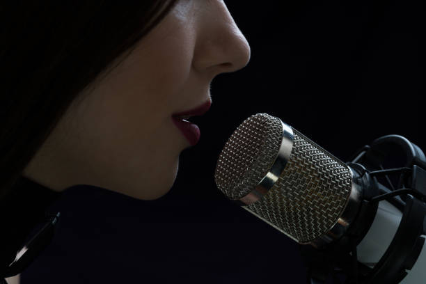 istock Singer in front of a microphone. Isolated on a dark background 871711416