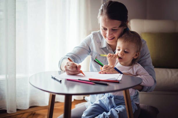 istock Mother drawing with her cute boy 871714188