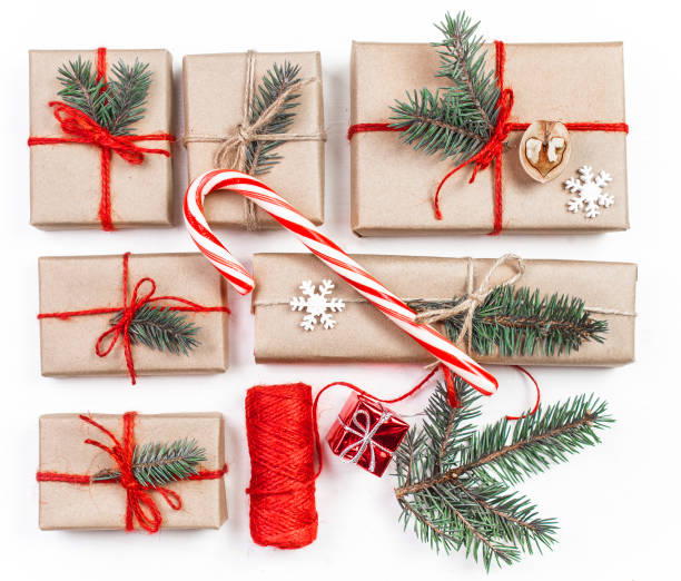 istock Christmas composition with holiday  presents, pine cones, fir branches isolated on white background. Flat lay, top view, Handmade gift boxes with craft paper