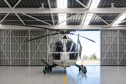 Rear view of the white clean helicopter situated in the hangar