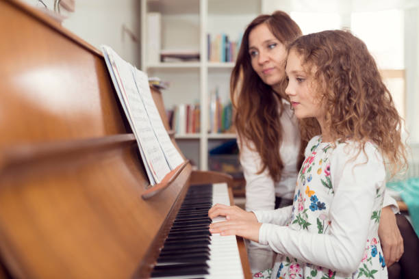 mutter tochter unterrichtet klavier spielen - music learning child pianist stock-fotos und bilder