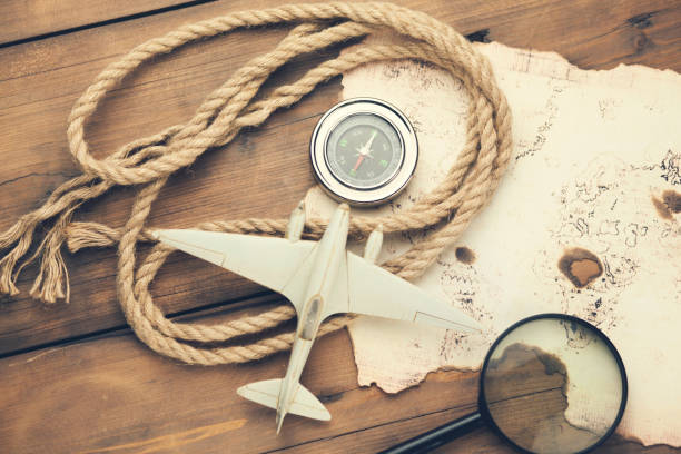 istock airplane, old map, compass with magnifier on wooden table 871737350