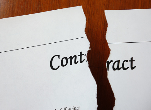 A legal contract ripped in two pieces on a desk