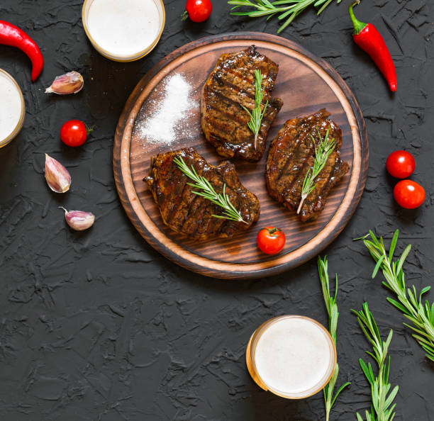 Appetizing beef steaks, beer and rosemary