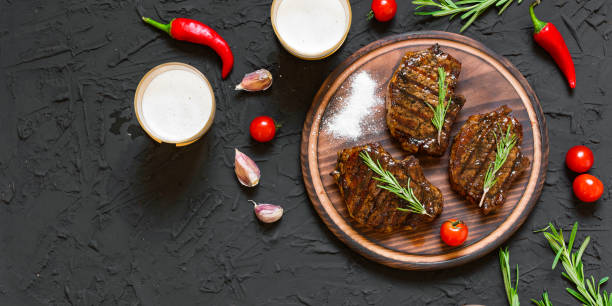 Appetizing beef steaks, beer and rosemary