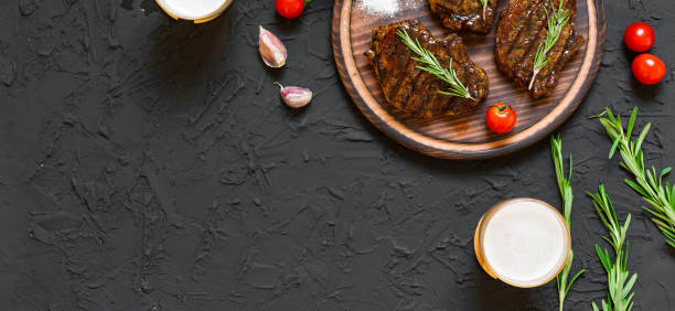 Appetizing beef steaks, beer and rosemary