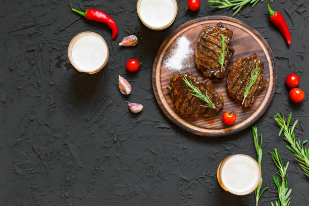 Appetizing beef steaks, beer and rosemary