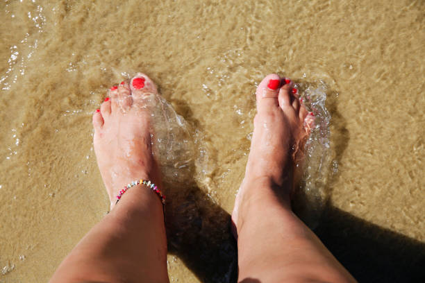 istock Sandy beach and girls feet 871752998