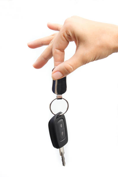 istock Female hand holding car keys on white background 871768666
