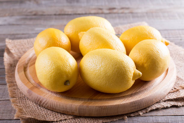 istock Fresh juicy lemons on a cutting board on a rustic wooden background 871772730