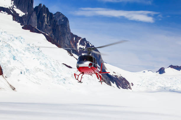 Helicopter Lands on Glacier A helicopter landing on a remote mountain glacier. base camp photos stock pictures, royalty-free photos & images
