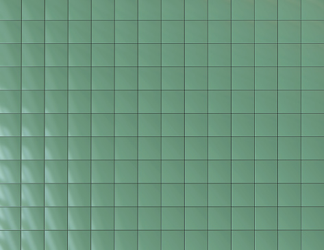 An exterior wall of plain green tiles.