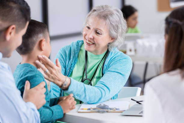 istock Cheerful senior volunteer nurse examines young boy 871778780