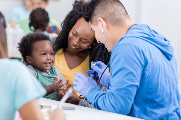 Adorable baby boy claps during medical exam