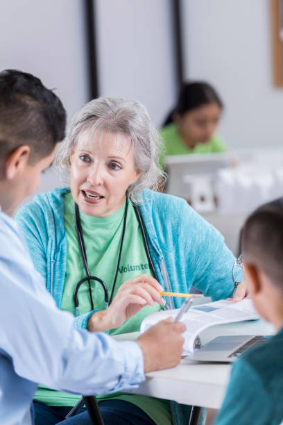 istock Serious volunteer nurse discusses paperwork with father and son 871778786