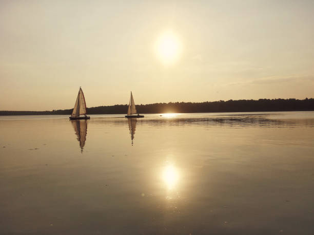 istock Sunset on lake with two sailboat. 871779298
