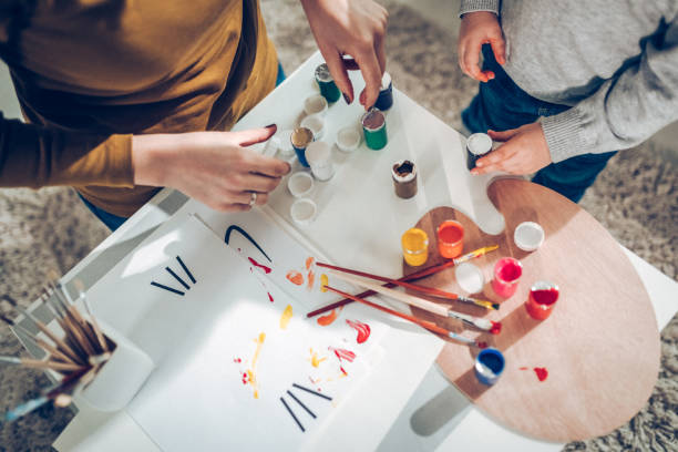 istock Mum with her son painting on paper 871789044
