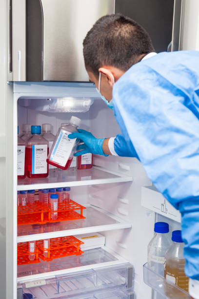 Male scientist and laboratory refrigerator