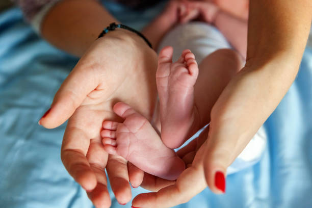 istock Baby feet and mother hands 871792732