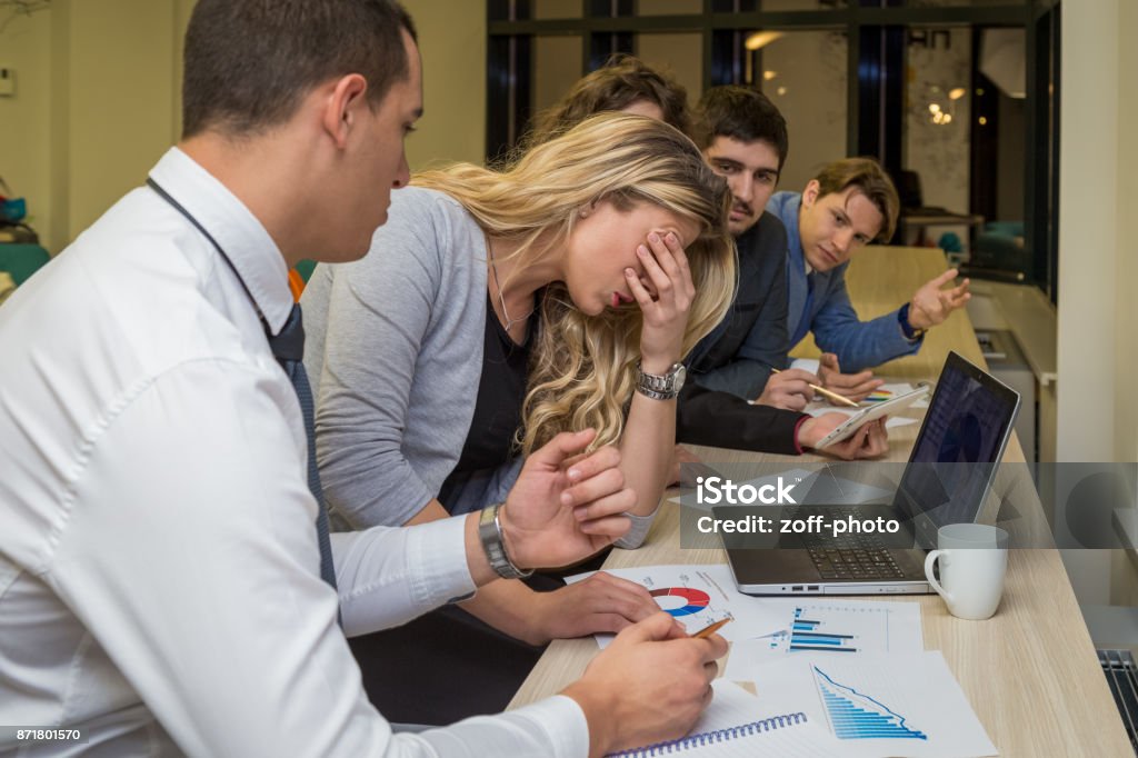 Unhappy businesswoman on a corporate meeting Unsatisfied businesswoman and her colleagues on internal meeting. Business problems concept. Crisis Stock Photo