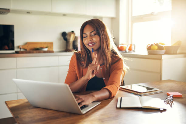 istock Young woman working online in her kitchen at home 871802002