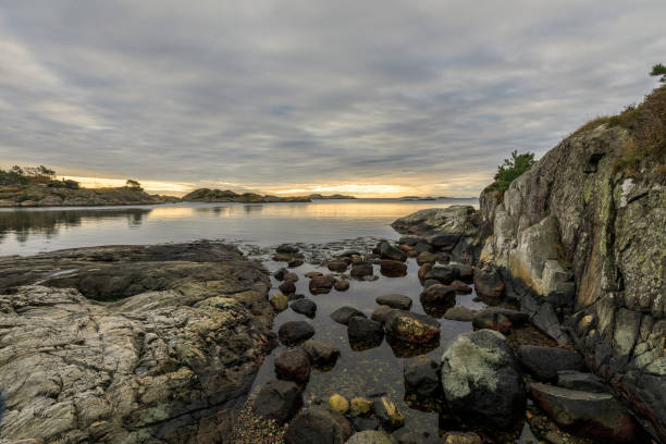 istock Seascape with rocks, sea and clouds. Grimstad in Norway 871802524